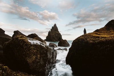 The formation of clouds during the day in the water under the black rock
